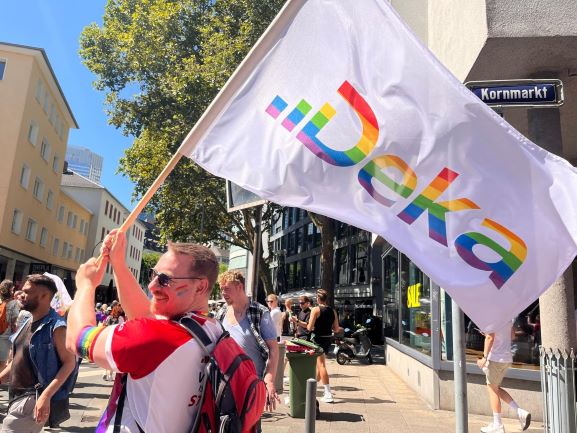 Deka-Mitarbeiter präsentiert die Deka-Flagge.
