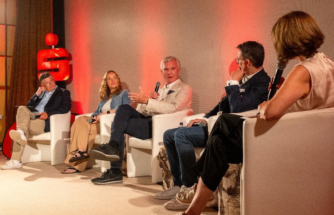 Drei Männer und zwei Frauen sitzen auf Sesseln und führen eine Podiumsdiskussion, darunter Deka-Vorstand Martin Müller