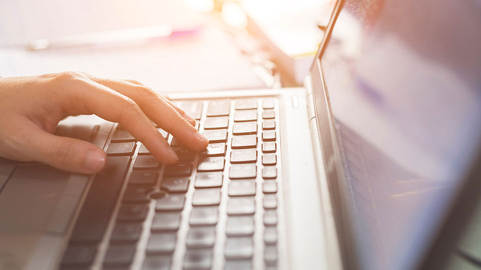 Hand auf einer Laptop-Tastatur