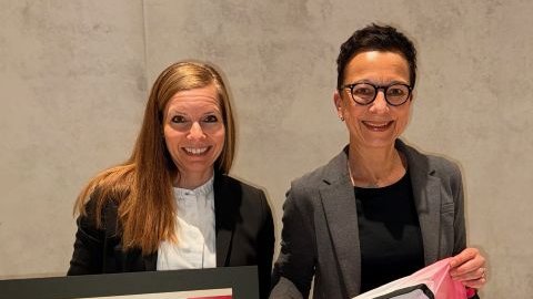 Zwei Frauen stehen nebeneinander und schauen in die Kamera