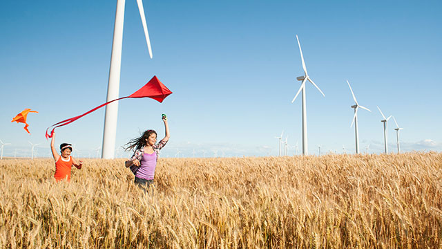 Spielende Kinder vor Windrädern