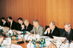 7 Personen während einer Pressekonferenz am Tisch.